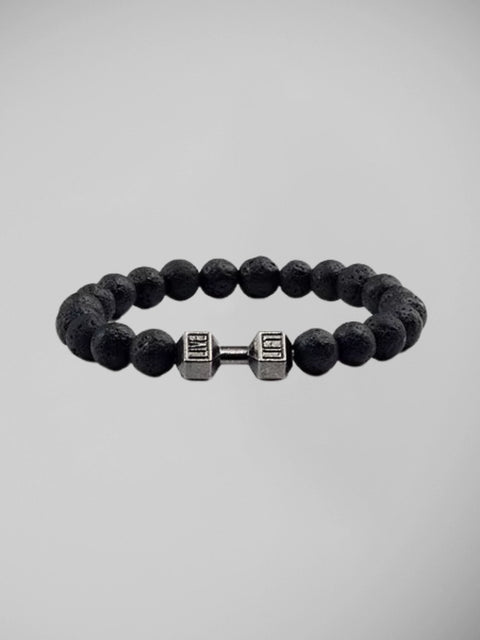 Pulseira masculina com contas de pedra vulcânica preta fosca e haltere metálico central, em fundo branco.


