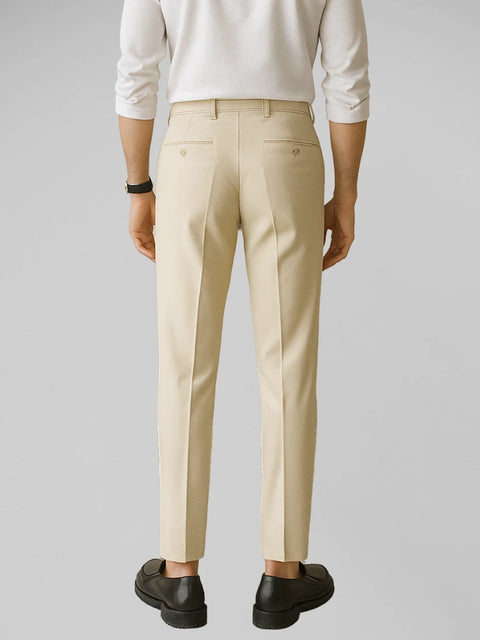 Homem em de costas com postura ereta, vestindo calça de alfaiataria ivory em fundo branco, mostrando caimento preciso e acabamento refinado no estilo Old Money.