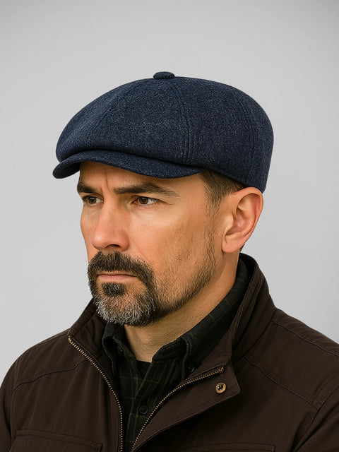 Boina masculina azul marinho com design europeu discreto, usada por modelo com barba e visual sóbrio em fundo neutro