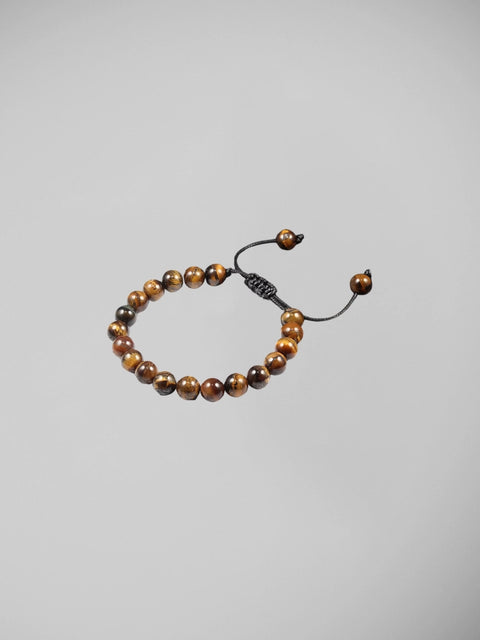 Pulseira olho de tigre usada por homem com camisa branca estilo sofisticado